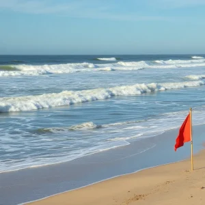 A beach scene showing strong rip currents with a warning flag