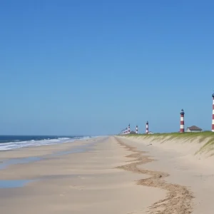 A beautiful view of the Outer Banks coastline with the ocean and a lighthouse.