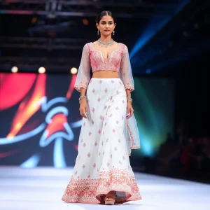 Model showcasing a white lehenga at a fashion show.