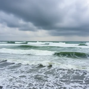 Turbulent ocean waves and dark clouds over the Outer Banks during a tropical storm warning.